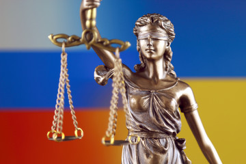 Symbol of law and justice with Ukraine and Russia Flag Flag. Close up.