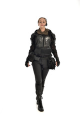 full length portrait of female  soldier wearing black  tactical armour, isolated on white studio background.