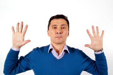 Portrait of a serious adult men dressed in blue sweater with their hands up
