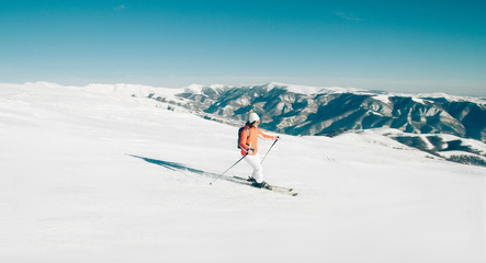 Woman Skier skiing down the slope in winter mountains