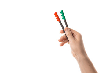 Male hand holds a two red and green markers or a felt pen. Isolated on white background.