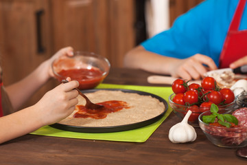 Spreading the sauce on a homemade pizza - closeup