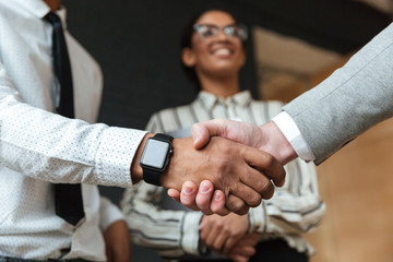 Cropped photo of handshake of young colleagues