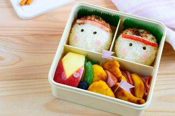 a cute and delicious looking onigiri bento on wooden background 