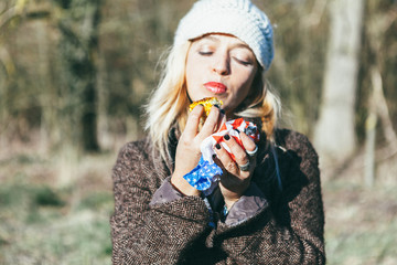 a young women eating a backed corn during an outdoor winter bbq. She holds on her left hand an USA flag serviette
