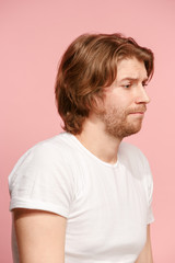 Let me think. Doubtful pensive man with thoughtful expression making choice against pink background