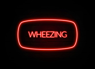 Wheezing neon sign on brick wall background.