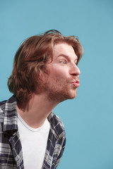 Obraz premium Portrait of attractive cute man with kiss isolated over blue background