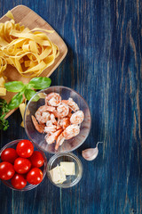 Ingredients ready for preparing pappardelle pasta with shrimp, t