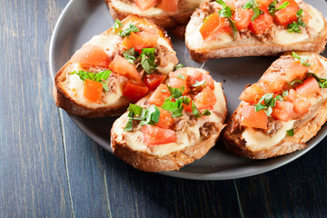 Appetizer bruschetta with tuna, mozarella cheese and tomatoes