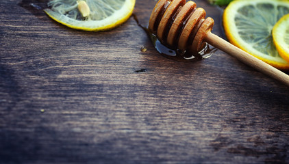 Honey and lemon. Honey stick and slices of sliced lemon on a woo