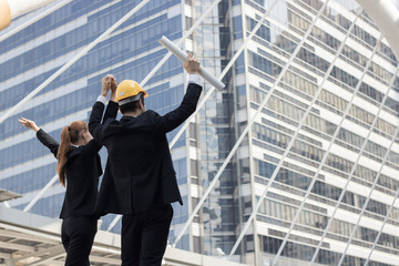 Hand coordination of team businesswoman and engineering on sky infront of bank building, office after successful project.