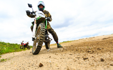 Close-up of mountain motocross race in dirt track in day time.