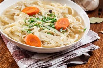 Tasty meat broth with noodles, carror and parsley