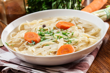 Tasty meat broth with noodles, carror and parsley