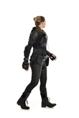 full length portrait of female  soldier wearing black  tactical armour, isolated on white studio background.