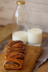 Fresh baked poppy seed roll and milk on the table  