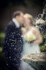 newlywed behind  fountain