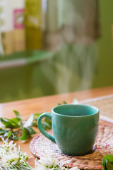 Steam of morning tea on table decorated with spring flowers
