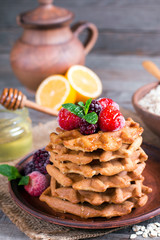 Fresh homemade waffles with berries and honey for breakfast on wooden background. Healthy breakfast