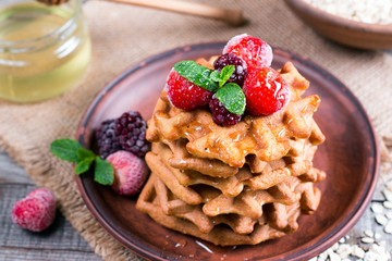 Fresh homemade waffles with berries and honey for breakfast on wooden background. Healthy breakfast