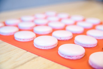 Obraz na płótnie Canvas Pink macarons on orange background