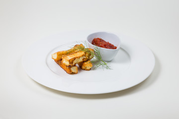 Fried halloumi and tomato dip on a white plate on a white background