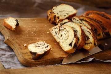 Fresh baked poppy seed roll on the table   