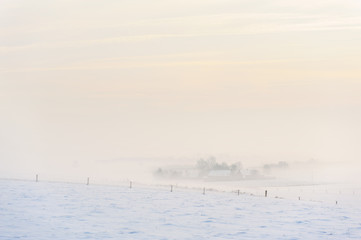 Snow covered farm and meadows in a winter scenery at the Poelberg in Tielt, West-Flanders