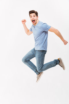 Full-length Photo Of Funny Man 30s In Casual T-shirt And Jeans Running Or Jumping In Air, Isolated Over White Background