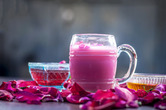 Indian/Asian popular summer drink i.e. Gulab Shake or Rose shake consisting of milk,rose syrup,sugar and honey with sabja seeds or sweet basil seeds in a transparent glass,with all ingredients.