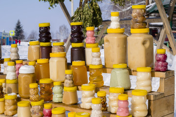 Fototapeta premium sale of honey and bath brooms on the counter on the street in winter