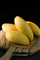 Ripe golden mangos with leaf on dark background