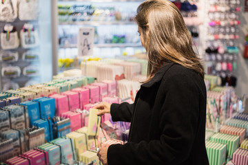 Woman consuming in a beautiful new shop of stationery buying and observing all the materials for sale in the bazaar
