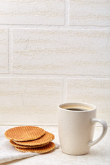 Top view closeup picture of tea in transparent cup with cookies and cotton napkin on white background, selective focus