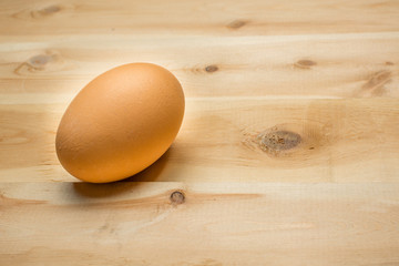 Yellow chicken egg lies on a wooden board