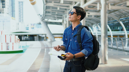 Young Handsome man looking over there and hold paper map