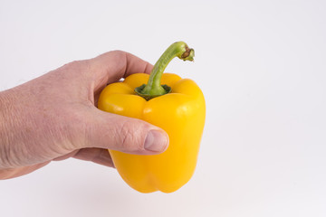 a yellow pepper in hand