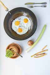 Simple morning breakfast, eggs, leek and breadsticks