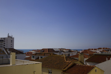 Fototapeta na wymiar the roofs of a small Portuguese town with the ocean in the background