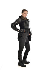 full length portrait of female  soldier wearing black  tactical armour, isolated on white studio background.