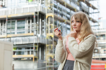 Woman with keys on front of new house building