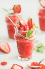 Healthy low calorie summer treat. Strawberry and champaigne granita, slushie or shaved ice dessert in glasses with mint, white background, selective focus. Clean eating, vegan, dieting food concept