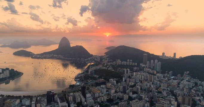 Flying towards sunrise over Sugarloaf Mountain in Rio de Janeiro, Brazil. High angle view