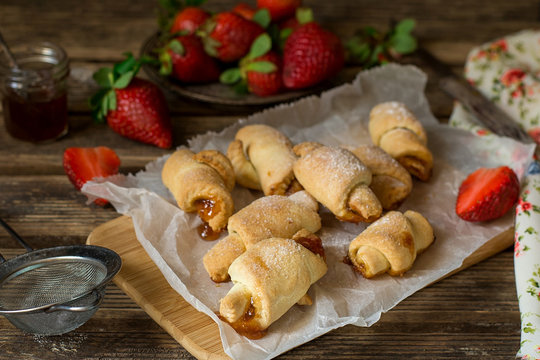 Sweet shortcrust pastry croissants in crescent shape filled with strawberry jam