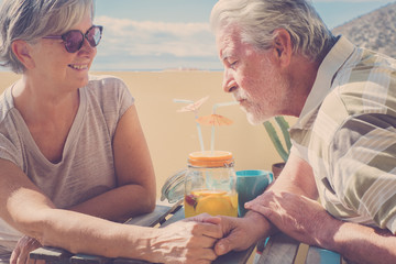 senior couple drinking together a fruit health jouce on the rooftop