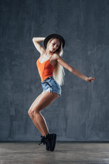 Obraz na płótnie Canvas Young beautiful female dancer is posing in the studio