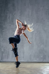 Fototapeta na wymiar Young beautiful female dancer is posing in the studio