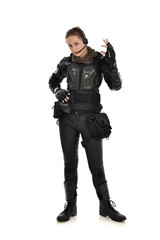 full length portrait of female  soldier wearing black  tactical armour, isolated on white studio background.