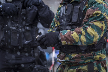 soldiers train shooting with a gun. a group of soldiers are practicing in cold snowy weather. perfectly equipped with equipment and camouflage clothing in muddy and dirty weather.